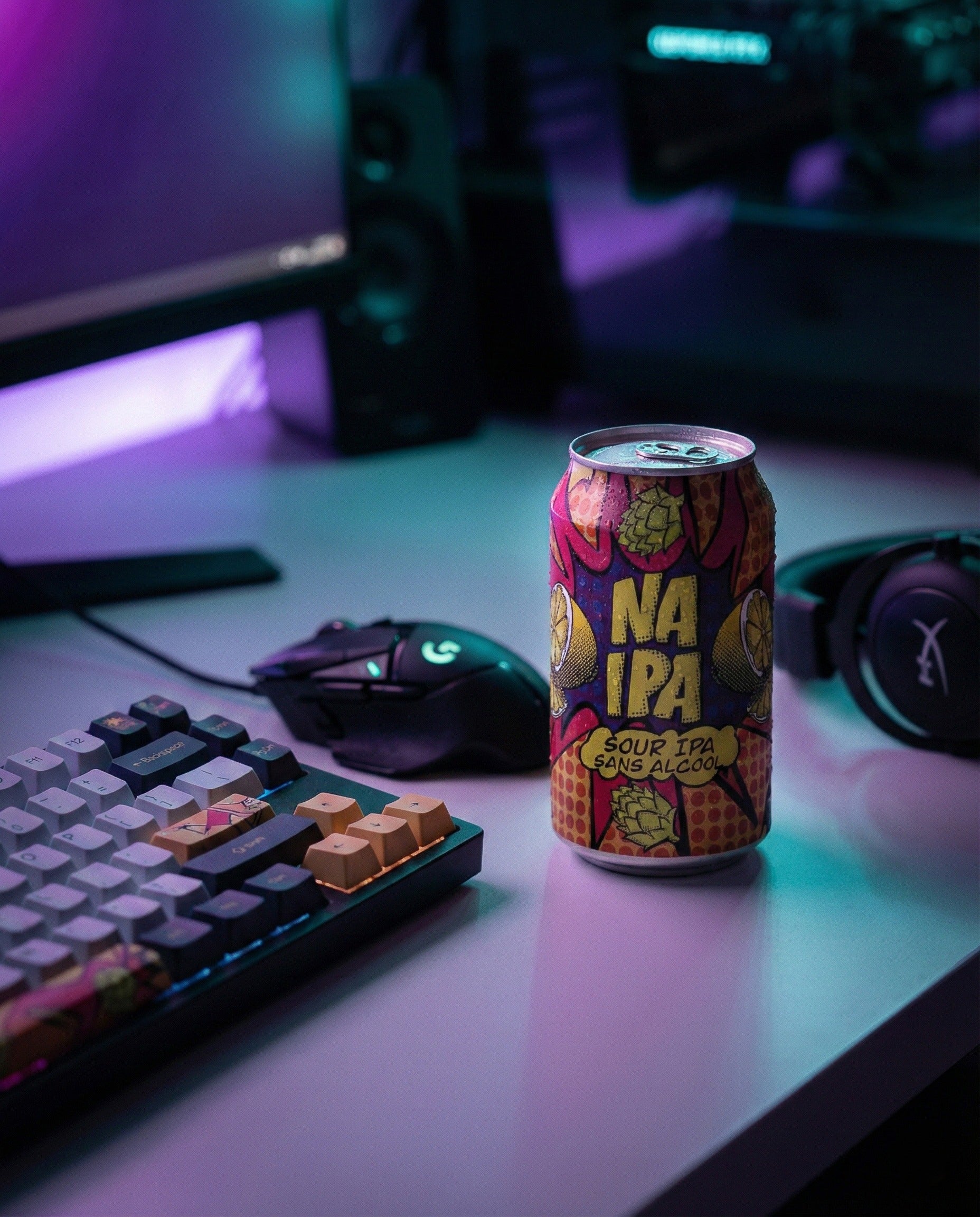 Avant-Garde NA Sour IPA can on a neon-lit desk beside a keyboard and headphones