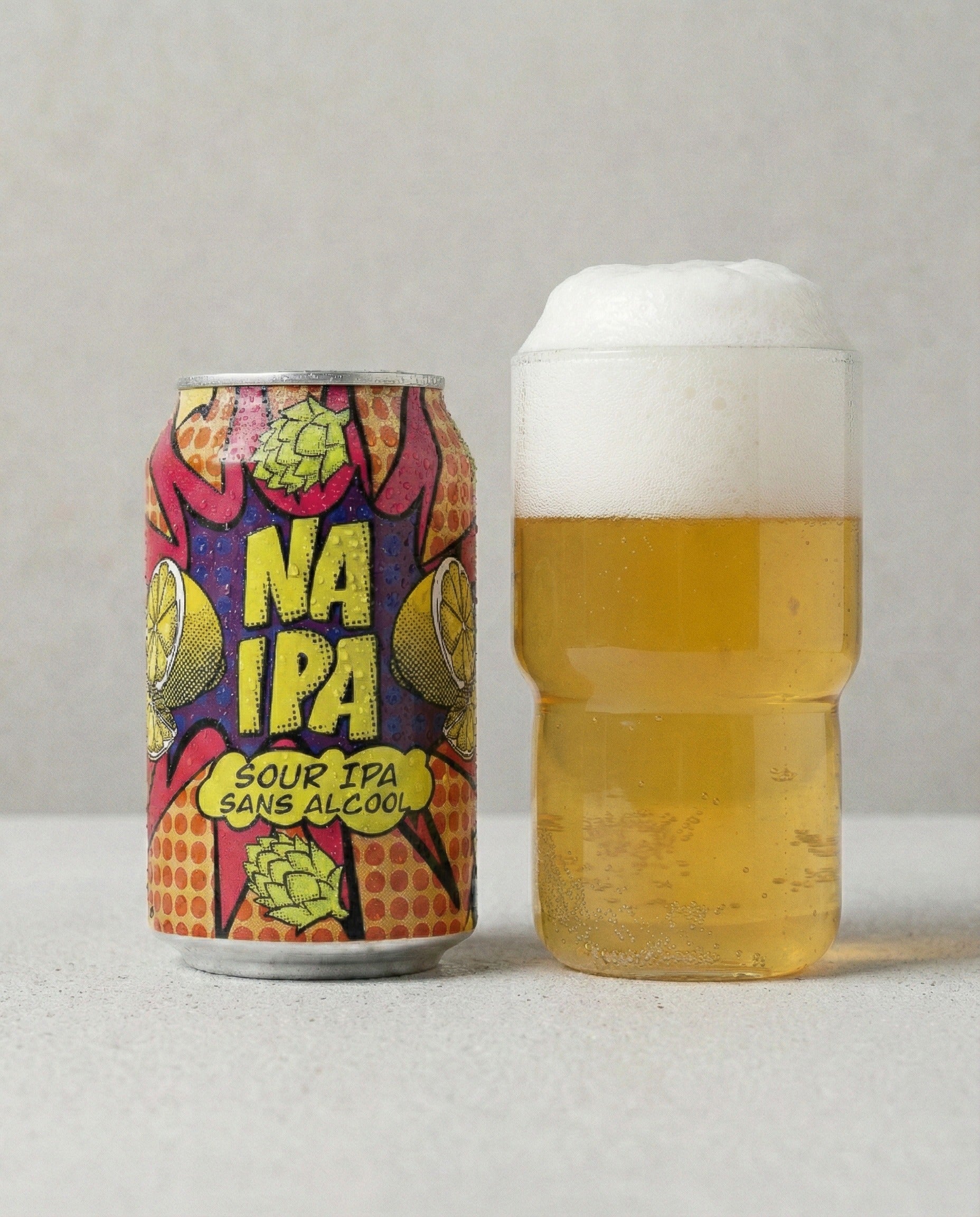 Avant-Garde NA Sour IPA poured into a glass beside the can, pale gold with white foam