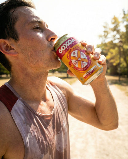 Goxoa Sportsbeer Blonde can on stone step in Provençal village with running shoes, towel and runner at golden hour