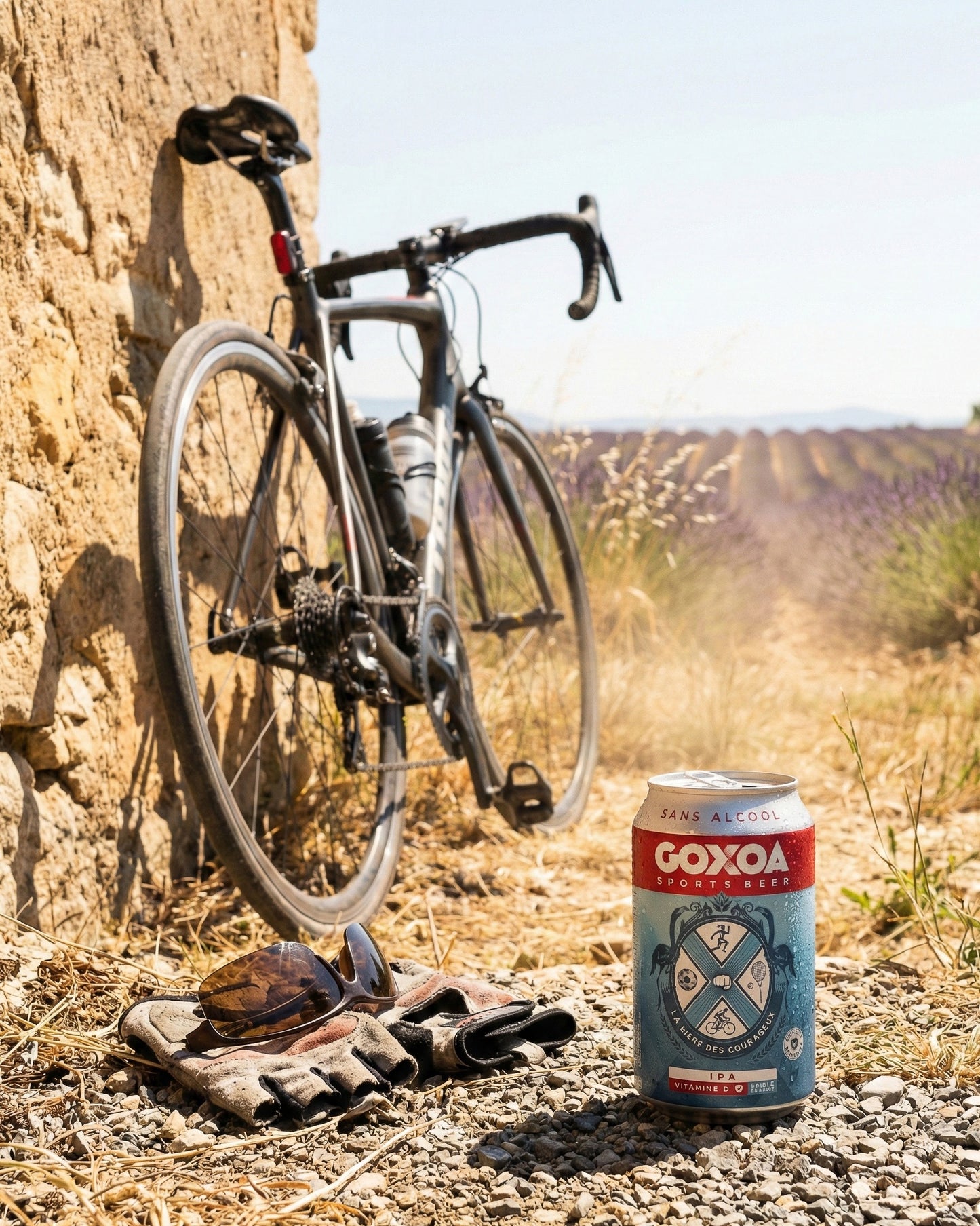 Goxoa Sportsbeer IPA can on gravel path with road bike, cycling sunglasses, gloves, Provence lavender field