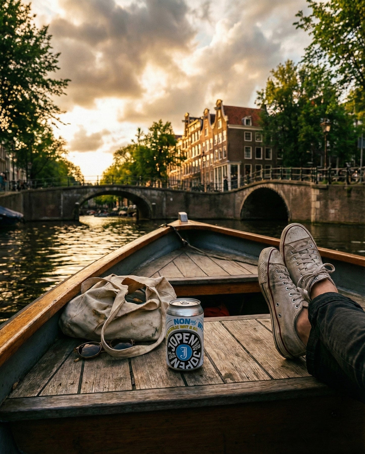 Jopen Nonnetje Wit can on the wooden deck of a boat on an Amsterdam canal at golden hour