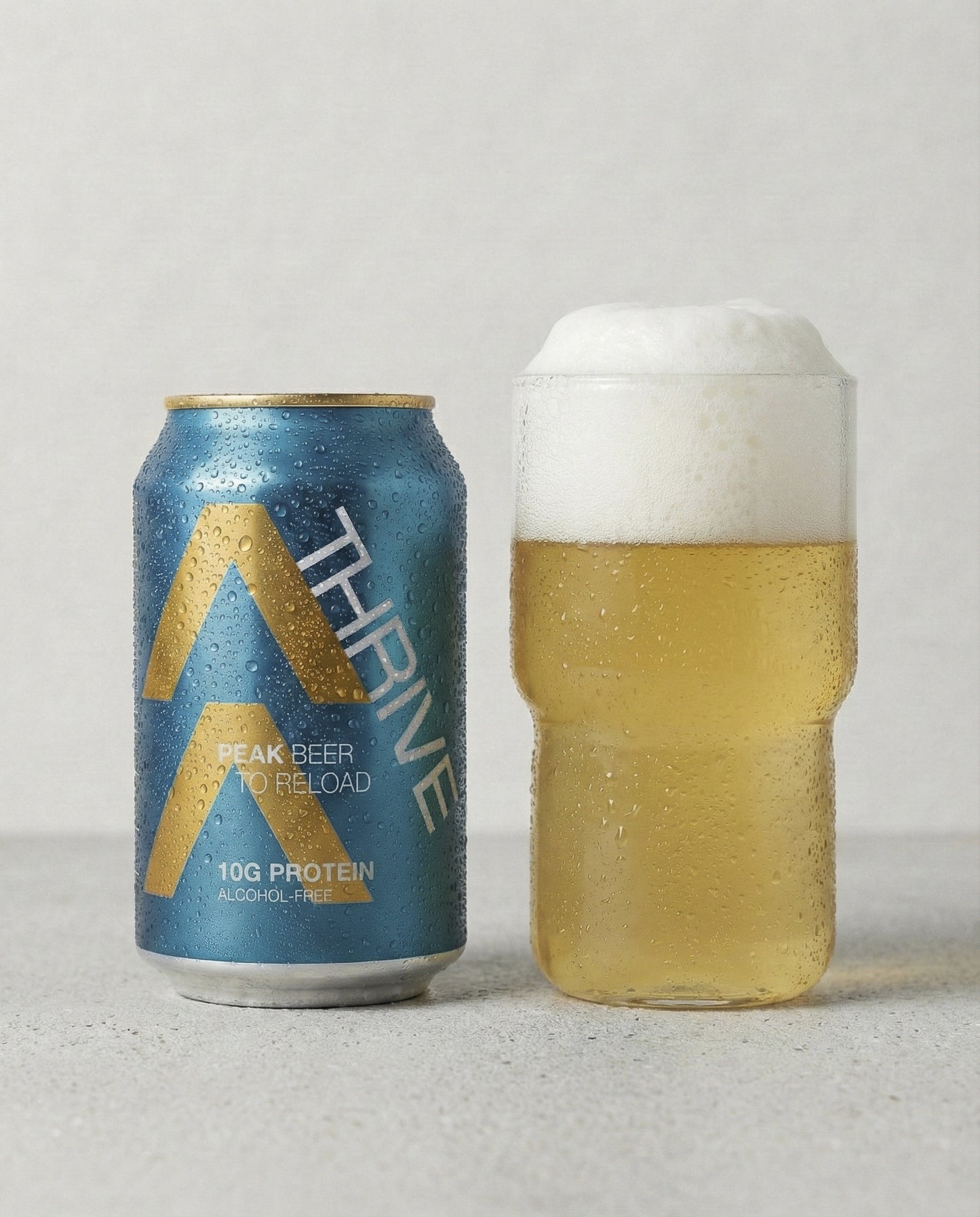 Thrive Peak Beer poured into a glass with foam head