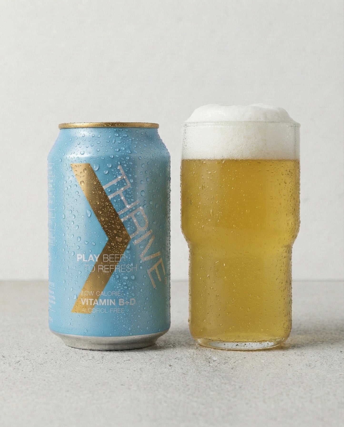 Thrive Play Beer poured into a glass with foam head