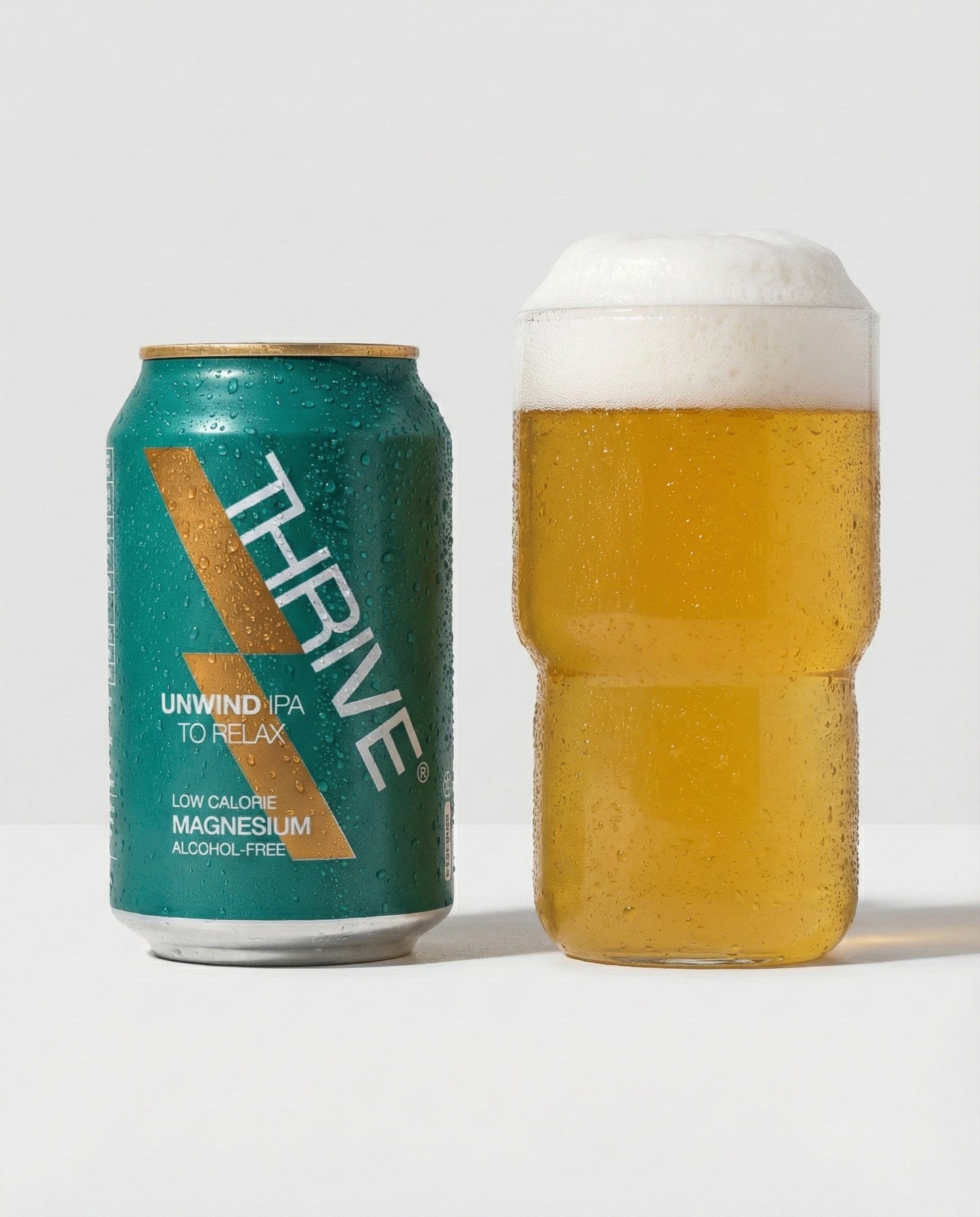 Thrive Unwind Beer poured into a glass with foam head