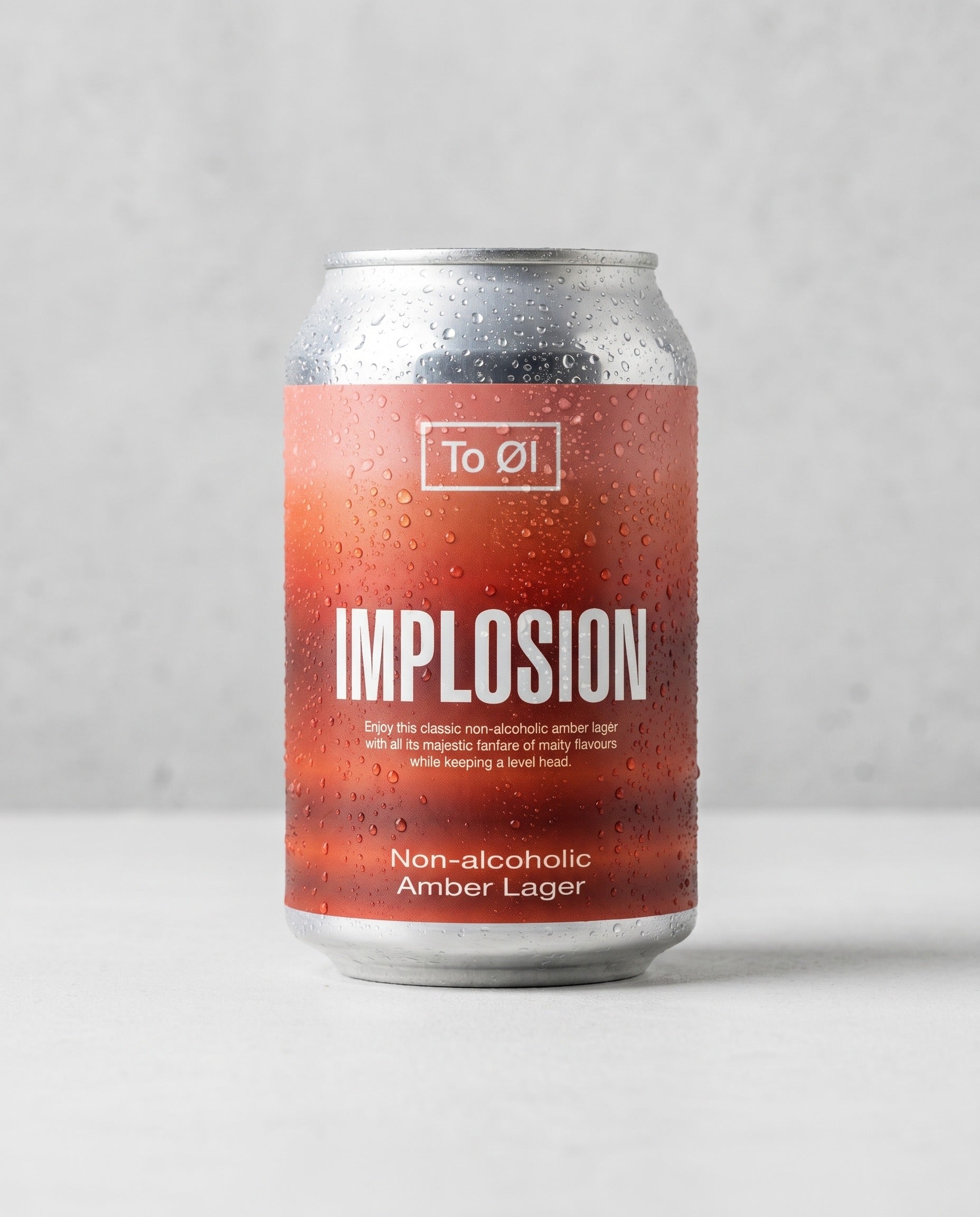 To Øl Implosion Amber Lager 0.5% alcohol-free can front view on concrete background