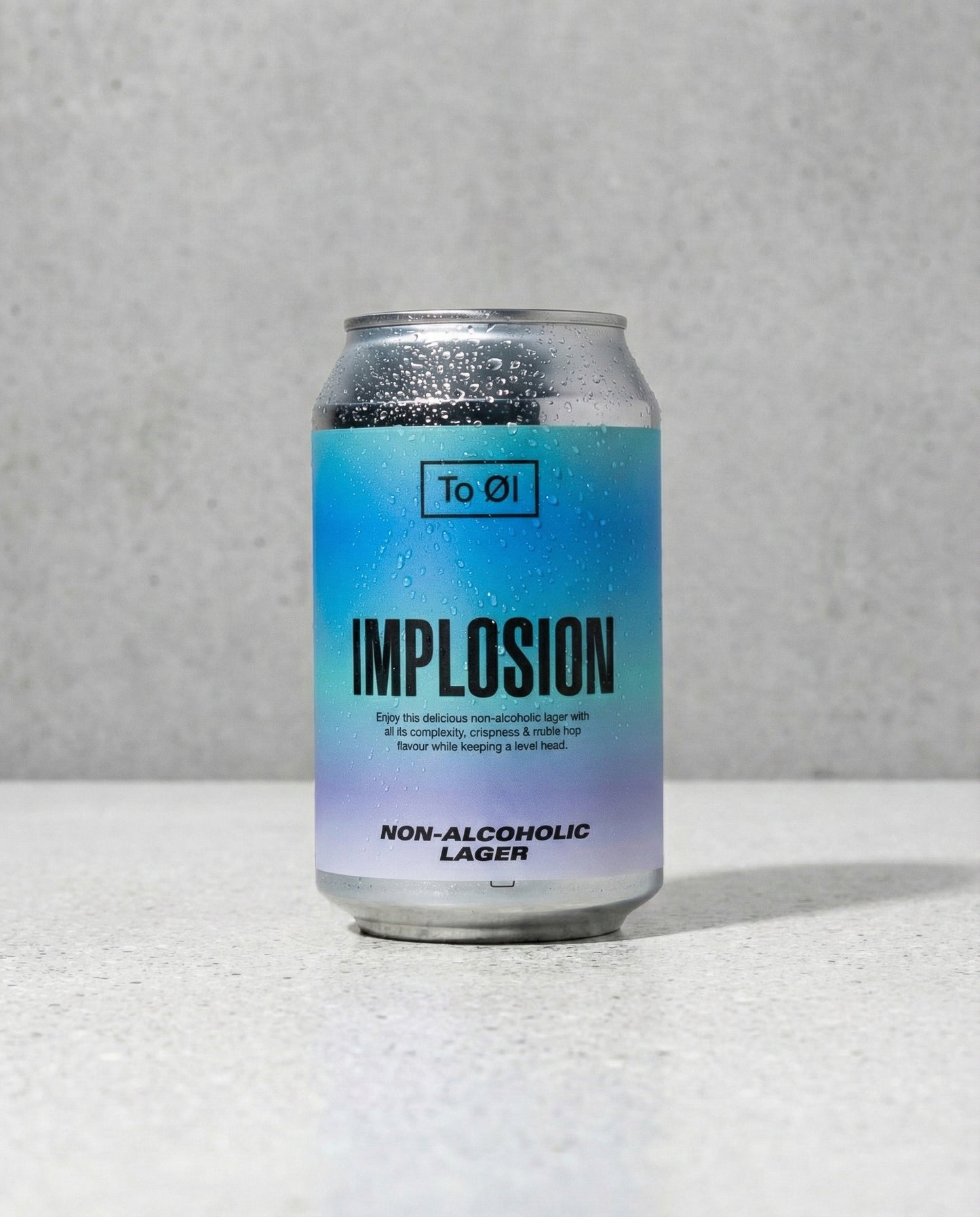 To Øl Implosion Lager can front view on concrete background