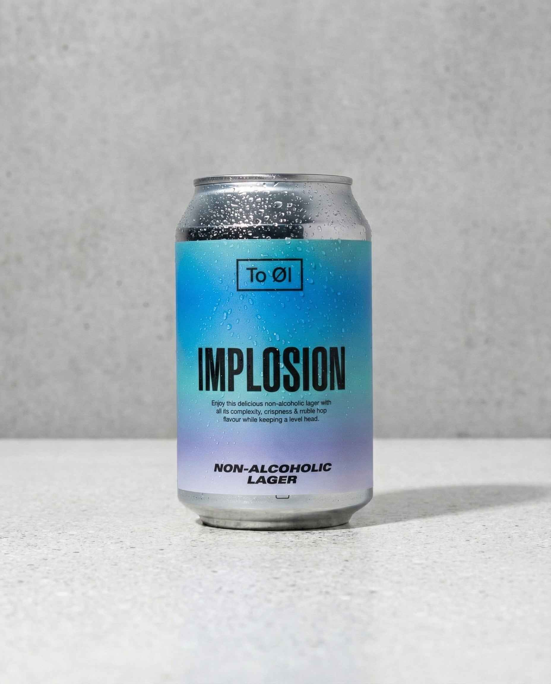 To Øl Implosion Lager can front view on concrete background