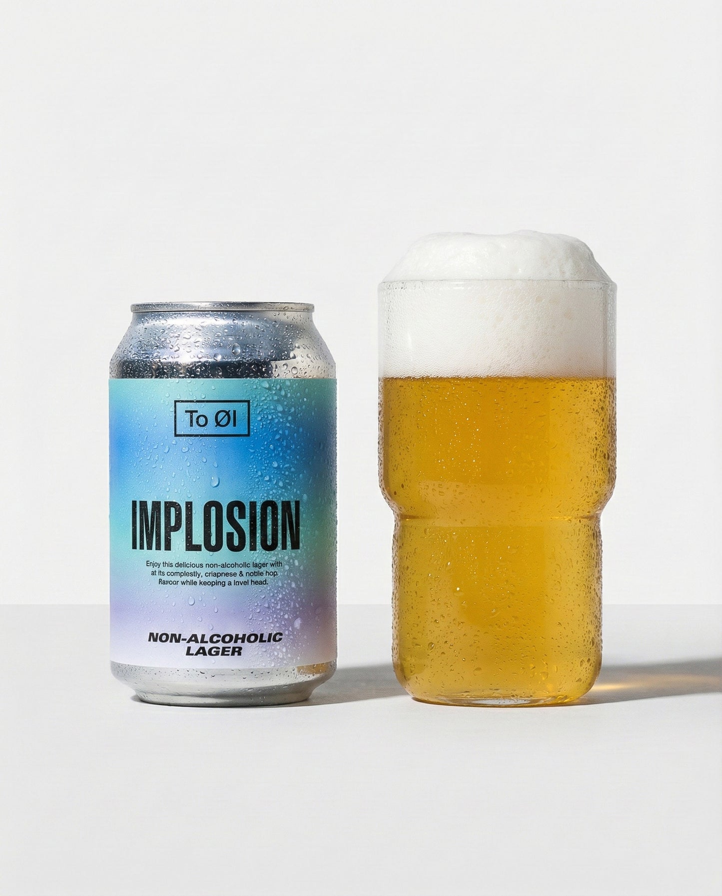 To Øl Implosion Lager poured into a glass with foam head