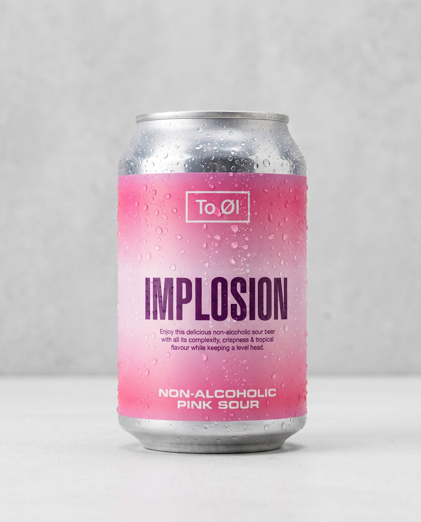 To Øl Implosion Pink Sour 0.5% alcohol-free can front view on concrete background