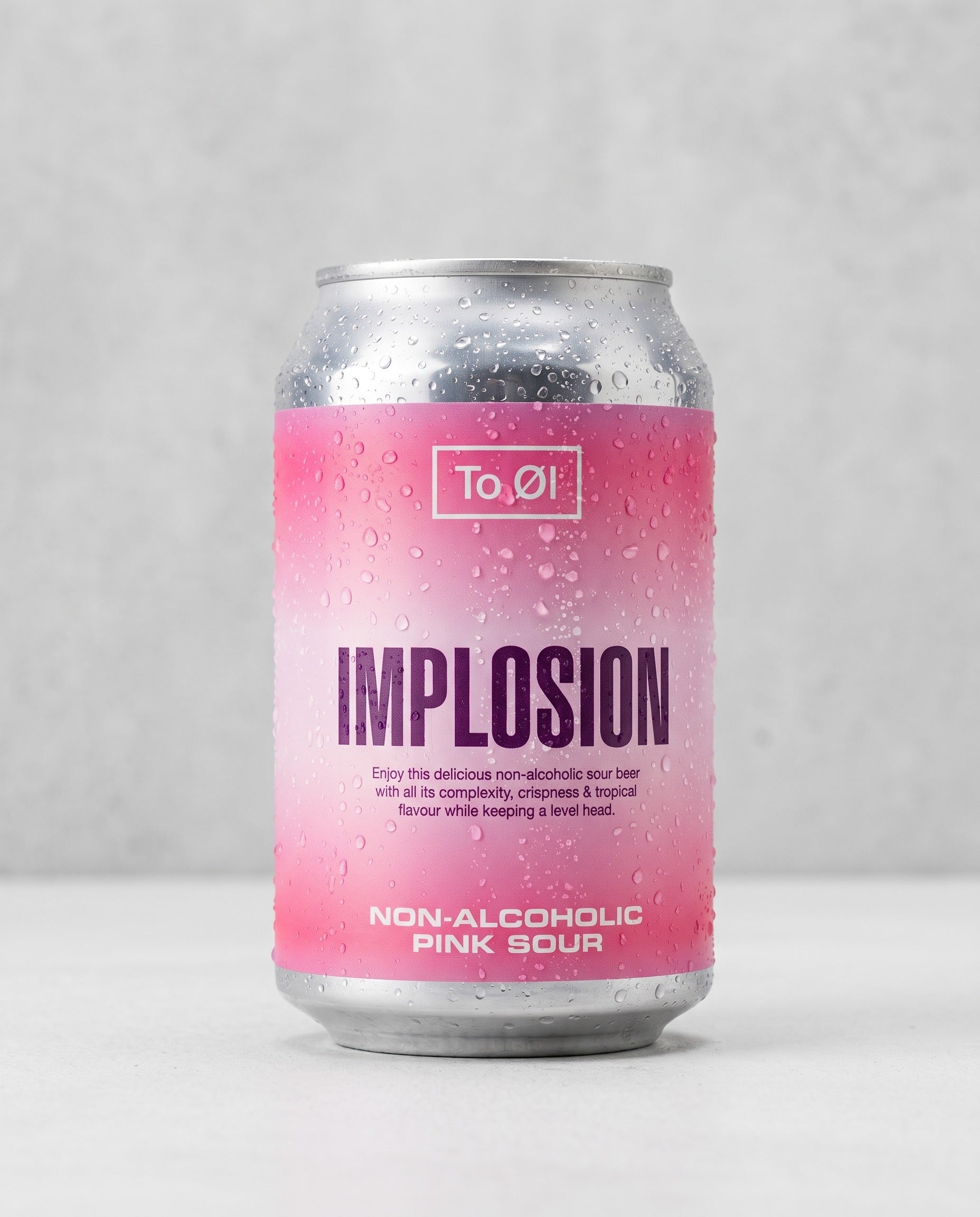 To Øl Implosion Pink Sour 0.5% alcohol-free can front view on concrete background