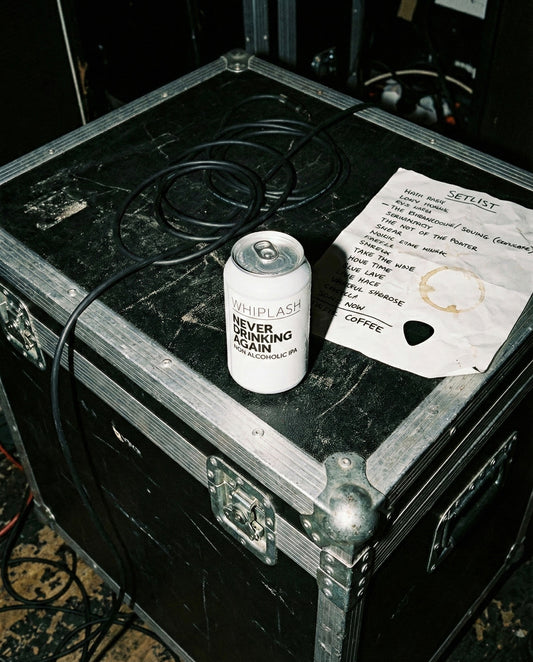Whiplash Never Drinking Again can on console table with turntable, headphones, vinyl records by sunlit window